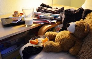 enant’s Abandoned Property, A messy desk, teddy bear sitting in the chair, a glass of milk in the table 