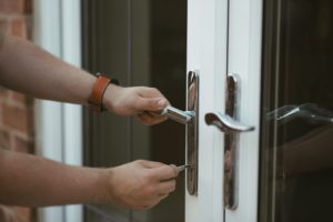 A man's hand trying to open a door