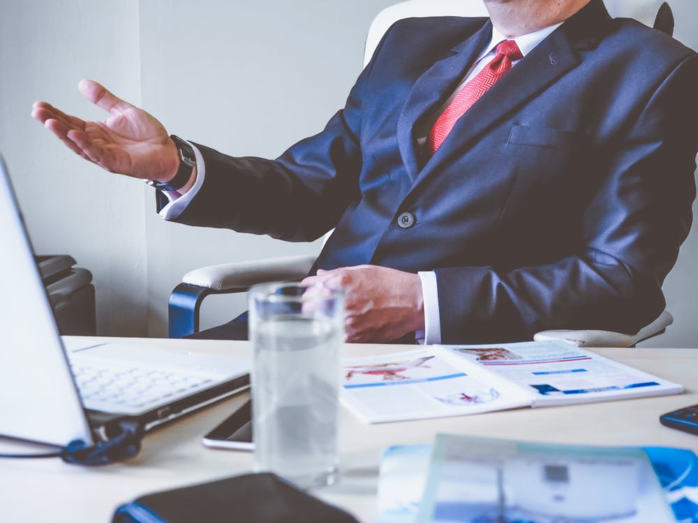 A businessman sitting in front of his desk and latptop while explaining Full Service Property Management for your Real Estate Clients