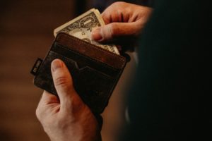 A mans hand getting his money in his wallet